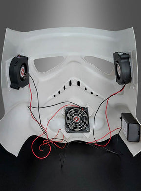 Innenansicht einer weißen Maske mit angebauten Lüftern, Kabeln und einer Stromquelle vor grauem Hintergrund – ideal, um Ihren Cosplay-Helm aufzuwerten oder Star-Wars-Kostümen mit dem Lüftersystem für Masken und Helme zusätzlichen Komfort zu verleihen.