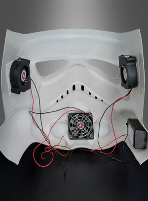 Innenansicht einer weißen Maske mit angebauten Lüftern, Kabeln und einer Stromquelle vor grauem Hintergrund – ideal, um Ihren Cosplay-Helm aufzuwerten oder Star-Wars-Kostümen mit dem Lüftersystem für Masken und Helme zusätzlichen Komfort zu verleihen.