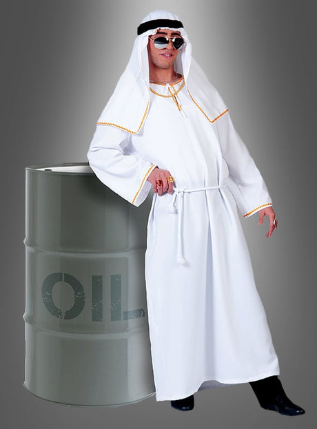 Eine Person, die ein Ölscheich-Araber-Kostüm trägt – eine weiße Robe und ein Kopftuch sowie eine Sonnenbrille –, steht neben einem großen Ölfass mit der Aufschrift „OIL“ vor einem grauen Hintergrund mit Farbverlauf.