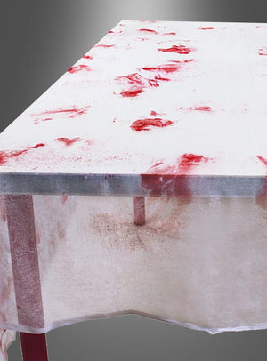 Ein rechteckiger Tisch ist mit der „Blutige Tischdecke Halloweendeko“ gedeckt, einem weißen Tuch, das mit roten Flecken übersät ist, die an Blut erinnern, vor einem grauen Hintergrund – ideal für Ihre Halloween-Dekoration.