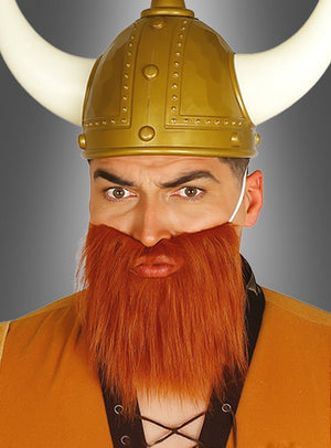Ein Mann, der einen goldenen Wikingerhelm mit weißen Hörnern und einen künstlichen roten Bart aus der Kollektion „Zwergenbart in verschiedenen Farben“ trägt, blickt mit ernstem Gesichtsausdruck direkt in die Kamera – perfekt für jede Fantasy-Kostümparty.