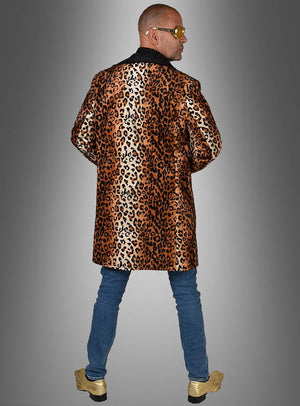 Eine Person, die das „Pimp Mantel Leo Herrenkostüm“ trägt – einen von klassischen Modellen inspirierten Mantel mit Leopardenmuster –, kombiniert mit blauen Jeans, goldenen Schuhen und einer Sonnenbrille, steht mit dem Rücken zu einem grauen Hintergrund mit Farbverlauf.