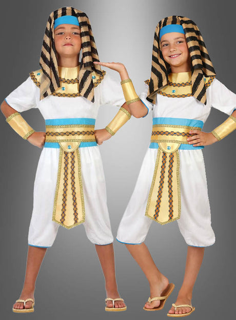 Zwei Kinder, die das „Ägyptisches Pharao“-Kinderkostüm tragen – mit weiß-goldenen Motiven aus dem alten Ägypten, blauen Akzenten, gestreiften Kopfbedeckungen und Sandalen –, stehen vor einem grauen Hintergrund. Die Kostüme eignen sich perfekt für Kinderfasching-Feiern und verkörpern den majestätischen Stil der alten Könige, ohne dabei auf Komfort und Spaß zu verzichten.