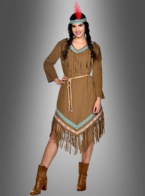 Eine Frau trägt das „Indianerin-Kostüm Rote Feder“ – ein braunes, fransiges Kleid mit Gürtel, Stiefeln und einem Stirnband mit einer roten Feder – und posiert vor einem grauen Hintergrund mit Farbverlauf; dieses mühelos stilvolle Kostüm eignet sich perfekt für jede Wilder-Westen-Kostümparty.