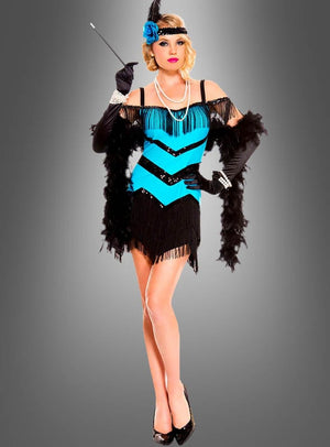 Eine Frau trägt das Flapperkleid mit Accessoires – ein blau-schwarzes Kleid mit Fransen, dazu ein Feder-Stirnband, schwarze Handschuhe, eine Federboa, eine Perlenkette und eine Zigarettenspitze – und steht vor einem grauen Hintergrund als das ideale 20er-Jahre-Kostüm für jedes Mottoparty-Outfit.