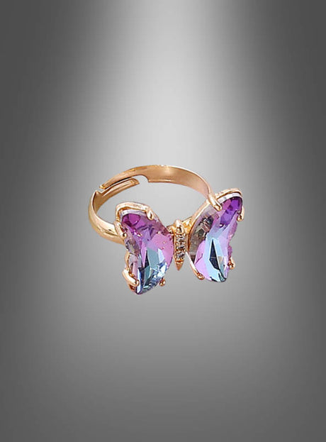 Wir präsentieren den „Verstellbaren Schmetterling-Ring aus Glas“ – einen atemberaubenden goldenen Ring, der mit einem aus zartem Glas gefertigten Schmetterlingsmotiv in Lila und Blau verziert ist. Vor einem eleganten grauen Hintergrund mit Farbverlauf präsentiert dieses Stück Kostümschmuck, das Frauen lieben werden, verleiht jedem Outfit mit seinen exquisiten Details aus Glas-Schmetterlingsschmuck einen einzigartigen Charme und Eleganz.