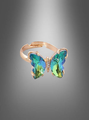 Wir präsentieren den „Verstellbaren Schmetterling-Ring aus Glas“ – einen goldenen Ring, der mit einem schmetterlingsförmigen Mittelstück verziert ist, auf dem blaue und grüne Edelsteine vor einem grau abgestuften Hintergrund zur Geltung kommen. Dieses exquisite Stück Glas-Schmetterling-Schmuck ist perfekt für Damen, die Wert auf elegante und einzigartige Accessoires legen.