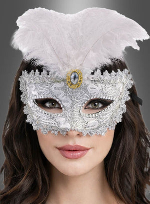 Eine Person, die die „Maskenball-Augenmaske mit Spitze, silber“ trägt, verziert mit weißen Federn und einem Zierstein, vor einem grauen Hintergrund mit Farbverlauf.