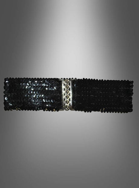 Ein rechteckiges Accessoire mit schwarzen Pailletten, das an den Stil der 80er-Jahre-Accessoires angelehnt ist, mit dem Titel „Pailletten-Gürtel für die Taille“, mit einem silbernen Mittelstreifen und vor einem grau verlaufenden Hintergrund.
