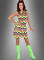 Eine Frau posiert in einem ärmellosen, mit Zickzackmustern verzierten, waschbaren Neon-Kleid im Stil der 80er Jahre in leuchtenden Neonfarben, kombiniert mit grünen kniehohen Stiefeln, einer orangefarbenen Sonnenbrille und bunten Armreifen – klassischen Neon-Accessoires – vor einem grauen Hintergrund mit Farbverlauf.