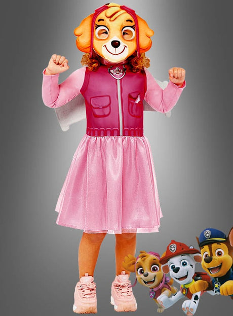 Eine Person, die das rosa „Skye“-Kostüm mit Paw-Patrol-Maske trägt, posiert mit angespannten Armen, während rechts unten animierte Paw-Patrol-Figuren zu sehen sind.