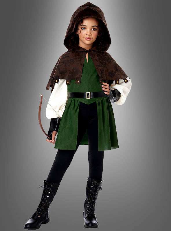 Ein Kind, das das „Robin Hood“-Kleid für Mädchen in Grün und Braun mit Kapuze und schwarzen Stiefeln trägt und einen kleinen Bogen in der Hand hält, steht vor einem grauen Hintergrund.