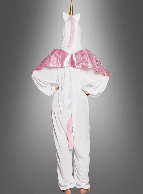 Eine Person, die das „Einhorn-Kostüm für Erwachsene in Weiß“ trägt – mit einem goldenen Horn, einer rosa Mähne und einem rosa Schweif sowie glänzenden rosa Flügeln –, steht mit den Händen in den Hüften und ist mit dem Rücken zum Betrachter gewandt.