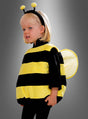 Ein kleines Kind, das ein schwarzes und gelbes „Plüsch-Bienenkostüm für Kinder Deluxe“ mit Flügeln und Fühlern trägt und vor einem grauen Hintergrund steht.