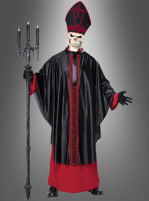 Eine Person im „Zombie-Priester“-Herrenkostüm – bestehend aus einer Skelettmaske, einer schwarz-roten Robe und einer hohen roten Mitra – hält einen mit Kerzen geschmückten schwarzen Dreizack in der Hand. Dieses auffällige Halloween-Kostüm für Herren ist ideal für alle, die ein authentisch gruseliges Mittelalter-Horror-Kostüm suchen. Das schaurige Ensemble setzt vor dem grauen Hintergrund ein dramatisches Statement.