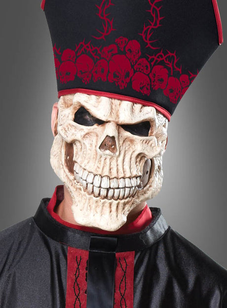 Eine Person im „Zombie Priester“-Herrenkostüm – bestehend aus einer großen Totenkopfmaske, einem schwarz-roten Kostüm und einem hohen Hut mit Totenkopfmotiven – posiert vor einem schlichten grauen Hintergrund. Dieses auffällige Outfit ist die ideale Wahl für alle, die ein beeindruckendes Halloween-Kostüm für Herren suchen oder die unheimliche Atmosphäre eines mittelalterlichen Horrorkostüms einfangen möchten.