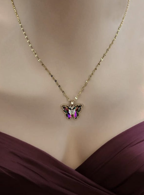 Trägt man die „Schmetterling Halskette schillernd“ – eine goldene Halskette mit einem schmetterlingsförmigen Anhänger, der mit rosa und violetten Akzenten verziert ist – zu einem burgunderroten, schulterfreien Kleid, entsteht ein elegantes Schmuckstück aus der „Schmetterling“-Kollektion und ein verspieltes Kostüm-Accessoire für jeden besonderen Anlass.
