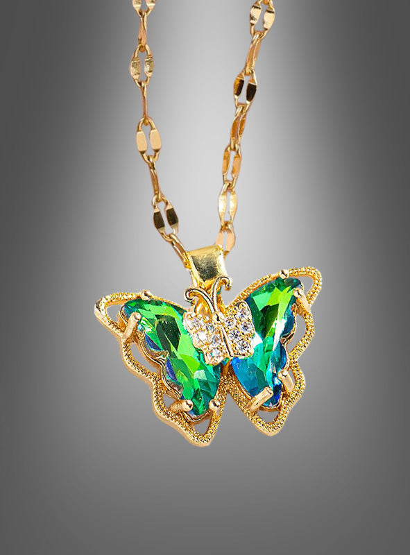 Wir präsentieren die „Schmetterling Halskette schillernd“ – eine Goldkette mit einem Schmetterlingsanhänger, besetzt mit schimmernden grünen und blauen Edelsteinen sowie zarten klaren Kristallen vor einem grauen Farbverlaufshintergrund. Dieses exquisite Schmuckstück ist das ideale Kostüm-Accessoire und verleiht jedem Outfit einen eleganten und bezaubernden Charme.