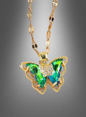 Wir präsentieren die „Schmetterling Halskette schillernd“ – eine Goldkette mit einem Schmetterlingsanhänger, besetzt mit schimmernden grünen und blauen Edelsteinen sowie zarten klaren Kristallen vor einem grauen Farbverlaufshintergrund. Dieses exquisite Schmuckstück ist das ideale Kostüm-Accessoire und verleiht jedem Outfit einen eleganten und bezaubernden Charme.