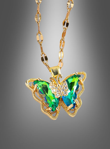 Wir präsentieren die „Schmetterling Halskette schillernd“ – eine Goldkette mit einem Schmetterlingsanhänger, besetzt mit schimmernden grünen und blauen Edelsteinen sowie zarten klaren Kristallen vor einem grauen Farbverlaufshintergrund. Dieses exquisite Schmuckstück ist das ideale Kostüm-Accessoire und verleiht jedem Outfit einen eleganten und bezaubernden Charme.