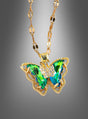 Wir präsentieren die „Schmetterling Halskette schillernd“ – eine Goldkette mit einem Schmetterlingsanhänger, besetzt mit schimmernden grünen und blauen Edelsteinen sowie zarten klaren Kristallen vor einem grauen Farbverlaufshintergrund. Dieses exquisite Schmuckstück ist das ideale Kostüm-Accessoire und verleiht jedem Outfit einen eleganten und bezaubernden Charme.