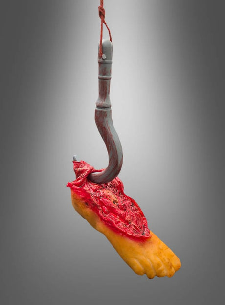 Leichenteil am Haken – Halloween-Dekoration – eine realistische Skulptur eines abgetrennten menschlichen Fußes, aufgeschnitten und an einem Metallhaken mit Seil vor grauem Hintergrund aufgehängt – perfekt als gruselige Dekoration oder als unheimlicher Blickfang für Halloween!.