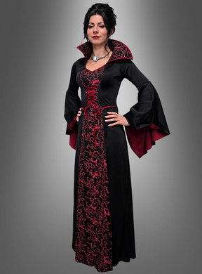 Vor einem grauen Hintergrund steht eine Frau, die das Kleid „Vampir Königin Mina Damen“ trägt – ein langes schwarz-rotes Kleid im Gothic-Stil mit ausgestellten Ärmeln und hohem Kragen.