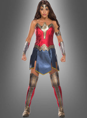 Eine Person, die das Deluxe-Wonder-Woman-Kostüm trägt, steht mit leicht angewinkelten Armen und geballten Fäusten nach vorne gerichtet und verkörpert vor einem schlichten grauen Hintergrund die Stärke der legendären DC-Superheldin.