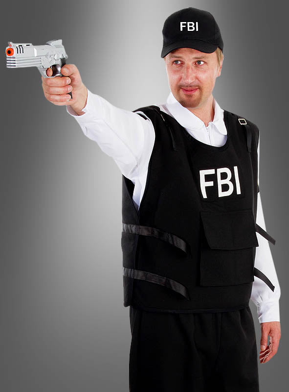 Eine Person trägt das FBI-Herren-Komplettkostüm, einschließlich Weste und Mütze, und steht vor einem grauen Hintergrund mit Farbverlauf, während sie eine silberne Spielzeugpistole nach vorne richtet.