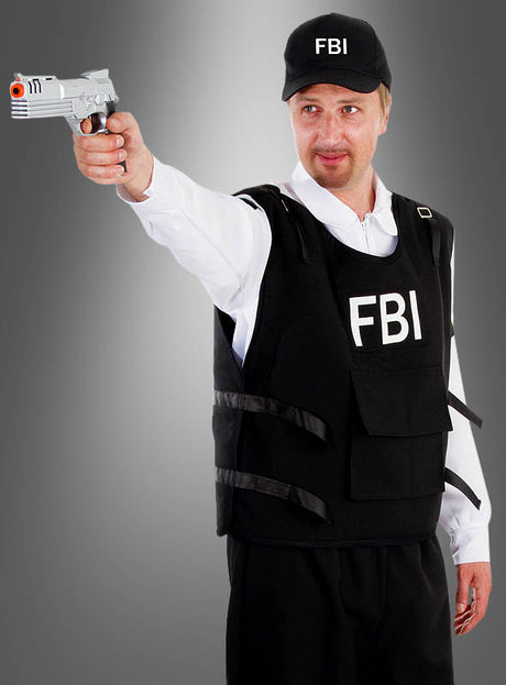Eine Person trägt das FBI-Herren-Komplettkostüm, einschließlich Weste und Mütze, und steht vor einem grauen Hintergrund mit Farbverlauf, während sie eine silberne Spielzeugpistole nach vorne richtet.