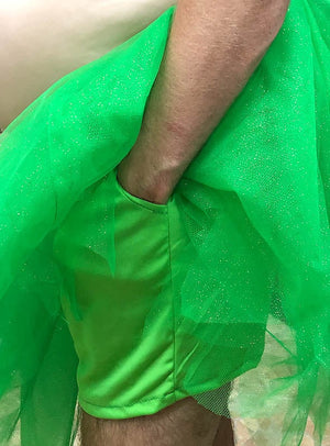 Jemand, der das „Trinkerbelly dicke Fee“-Männerkostüm mit Perücke trägt – mit seinem leuchtend grünen Tutu und den dazu passenden Shorts, die den nackten Oberkörper und die Arme betonen –, ist die perfekte Wahl als lustiges Feen-Kostüm für Männer oder als urkomisches Junggesellenabschied-Kostüm.
