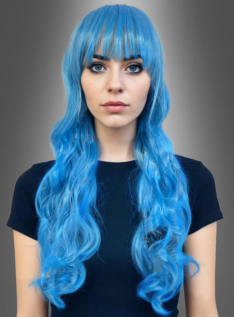 Eine Person mit langen, welligen blauen Haaren und Pony, die ein schlichtes schwarzes Kurzarm-Shirt trägt und vor einem grauen Hintergrund mit Farbverlauf posiert – perfekt, um die Langhaar-Lockenperücke 80 cm „Godiva“ als Teil eines einzigartigen Fantasy-Kostüms in Szene zu setzen.