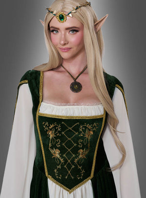 Vor einem grauen Hintergrund steht eine Frau in einem grün-weißen Kleid im mittelalterlichen Stil mit goldener Stickerei, spitzen Elfenohren, einem grünen, mit Edelsteinen besetzten Diadem und langen blonden Haaren – ein bezaubernder „Elfenkönigin Emerald Damenkostüm“-Look, der die Magie eines Elfenkönigin-Kleides perfekt verkörpert.