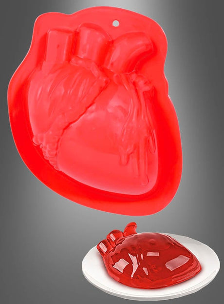 Eine rote Silikonform aus der Kollektion „Halloween-Puddingformen: Herz, Gehirn oder Hand“ in Form eines anatomischen Herzens ist über einem Teller ausgestellt, auf dem rote Gelatine in derselben Herzform gegossen ist – ideal für die Zubereitung gruseliger Desserts zu Halloween.
