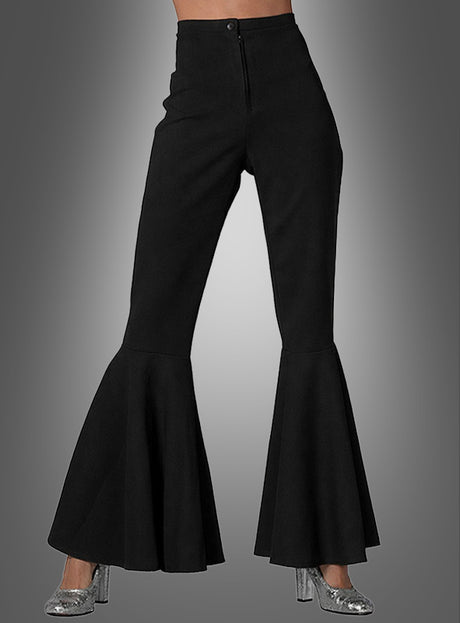 Ein Model präsentiert die hoch taillierte schwarze Schlaghose „Schlaghose Damen schwarz“ in Kombination mit silbernen Glitzer-High-Heels vor einem grauen Hintergrund mit Farbverlauf.