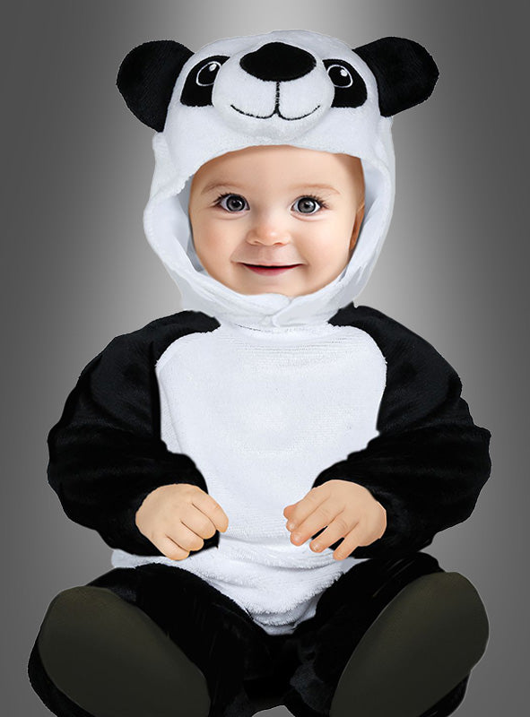 Ein Baby sitzt mit dem Gesicht nach vorne und trägt das „Süßes Panda-Kostüm für Kinder“ – einen bezaubernden schwarz-weißen Overall mit einer Kapuze, auf der ein Pandagesicht abgebildet ist – vor einem einfarbigen grauen Hintergrund.