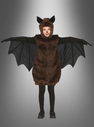 Ein Kind in einem Plüsch-Fledermaus-Kostüm für Kinder steht mit ausgestreckten Armen vor einem grauen Hintergrund mit Farbverlauf und ist bereit, sich in den Halloween-Spaß zu stürzen.