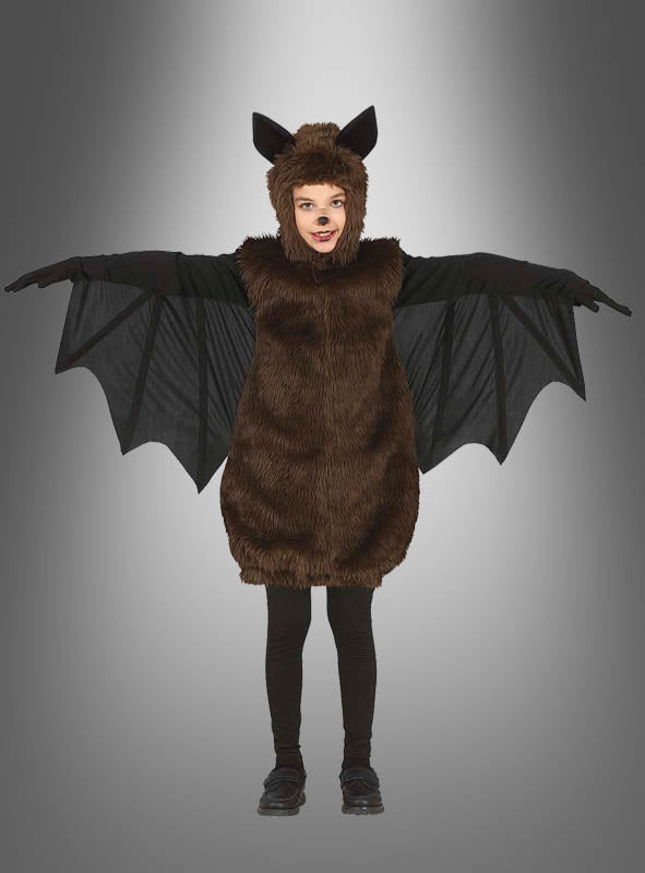 Ein Kind in einem Plüsch-Fledermaus-Kostüm für Kinder steht mit ausgestreckten Armen vor einem grauen Hintergrund mit Farbverlauf und ist bereit, sich in den Halloween-Spaß zu stürzen.