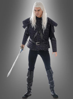 Eine Person in schwarzer Rüstung im mittelalterlichen Stil mit langen weißen Haaren hält ein Schwert in der Hand und steht vor einem grauen Hintergrund mit Farbverlauf – ein markanter Look, der sich perfekt für jedes „Witcher“-Kostüm für Herren oder Fantasy-Cosplay eignet.