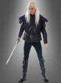 Eine Person in schwarzer Rüstung im mittelalterlichen Stil mit langen weißen Haaren hält ein Schwert in der Hand und steht vor einem grauen Hintergrund mit Farbverlauf – ein markanter Look, der sich perfekt für jedes „Witcher“-Kostüm für Herren oder Fantasy-Cosplay eignet.