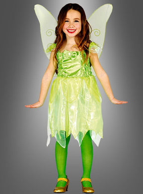 Ein Kind trägt das „Kleine Fee“-Mädchenkostüm mit zarten Flügeln, einem grünen Kleid, passenden grünen Strumpfhosen und goldenen Schuhen und lächelt vor einem grauen Hintergrund mit Farbverlauf – ein zauberhafter Look, perfekt für die Kleinen, die von Magie träumen.