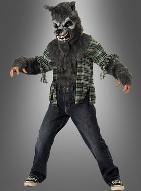 Ein Kind, das das „Kinder-Werwolf-Kostüm“ für Halloween trägt – bestehend aus einer knurrenden Maske, pelzigen Handschuhen, einem karierten Hemd und Jeans –, steht vor einem grauen Hintergrund.