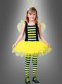 Ein kleines Mädchen steht mit dem Blick nach vorne und trägt das „Emsiges Bienchen“-Kinderkostüm mit gelben und schwarzen Streifen, zarten Flügeln, einem Tutu-Rock, gestreiften Leggings und einem Stirnband mit Fühlern vor einem schlichten grauen Hintergrund. Dieses bezaubernde „Kinderkostüm Biene“ eignet sich perfekt für Fasching oder zum Verkleiden.