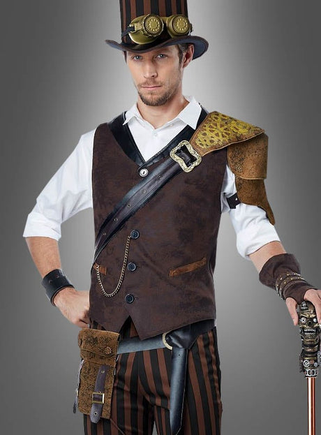 Ein Mann im „Steampunk-Abenteurer“-Kostüm, bestehend aus einer braunen Weste, einer gestreiften Hose, einem Zylinder mit Schutzbrille, Lederaccessoires und einem mechanischen Spazierstock, steht vor einem grauen Hintergrund.