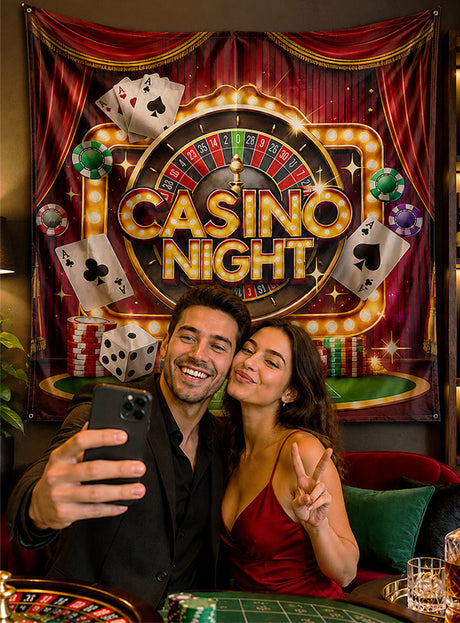 Ein Mann und eine Frau machen ein Selfie vor einem „Casino Night“-Stoffhintergrund (185 x 190 cm, waschbar), auf dem farbenfrohe Spielkarten, Jetons und ein Roulette-Rad abgebildet sind, die eine festliche Atmosphäre im Innenbereich schaffen.