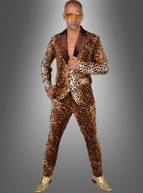 Ein Mann im Zuhälter-Kostüm „Cool Man“ im Leoparden-Look – mit einer goldenen Kette, einer gelben Sonnenbrille und goldenen Schuhen – steht selbstbewusst vor einem grauen Hintergrund und verkörpert den kühnen Stil eines klassischen Zuhälter-Kostüms.