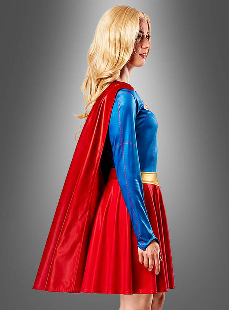 Eine Person trägt das „Supergirl“-Kostüm für Damen von DC Comics, bestehend aus einem blauen Oberteil, einem roten Rock und einem roten Umhang; im Profil sind vor einem schlichten grauen Hintergrund blonde Haare zu sehen. Dieses auffällige Kostüm gibt den ikonischen Superhelden-Look originalgetreu wieder.
