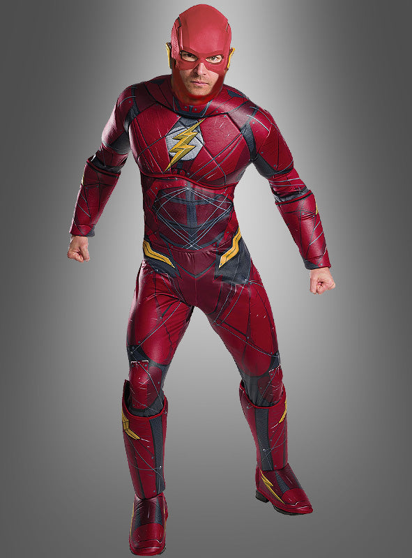 Eine Person in einem roten Superheldenkostüm mit einem gelben Blitz-Emblem steht mit geballten Fäusten vor einem grauen Hintergrund und bringt damit den ikonischen Stil des „Deluxe Flash Herrenkostüms“ aus der Justice League perfekt zur Geltung.