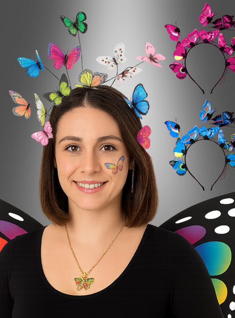 Eine Frau, die Schmetterlings-Accessoires trägt, darunter ein „Schmetterling Haarreif mit LED“-Stirnband, eine Halskette, einen Gesichtssticker und Flügel, während hinter ihr an der Wand drei „Schmetterling Haarreif mit LED“-Stirnbänder ausgestellt sind.