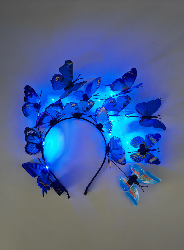 Ein Schmetterling-Haarreif mit LED, verziert mit blauen Kunstschmetterlingen und kleinen blauen LED-Lichtern, ideal als Ergänzung zu deinem Schmetterlingskostüm, präsentiert vor einem schlichten Hintergrund.